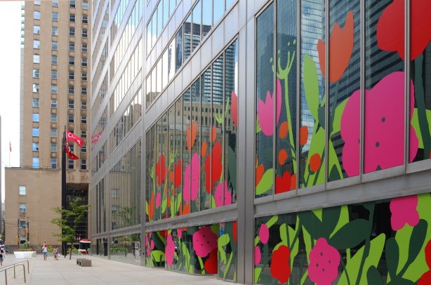 the glass walls of the window of Commercce Court are covered with pictures of pink and red flowers, blooms in the city art project 