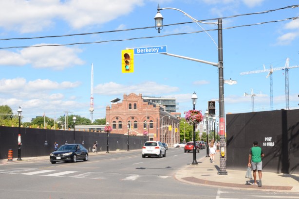 intersection of Berkeley and Front, looking east on Front towards police station in old building, black hoardings for construction sites on both sides of Front Street 