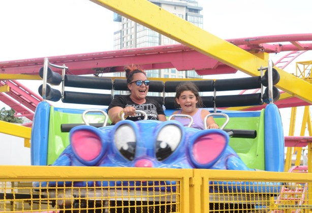 mother and daughter screaming and laughing on roller coaster ride