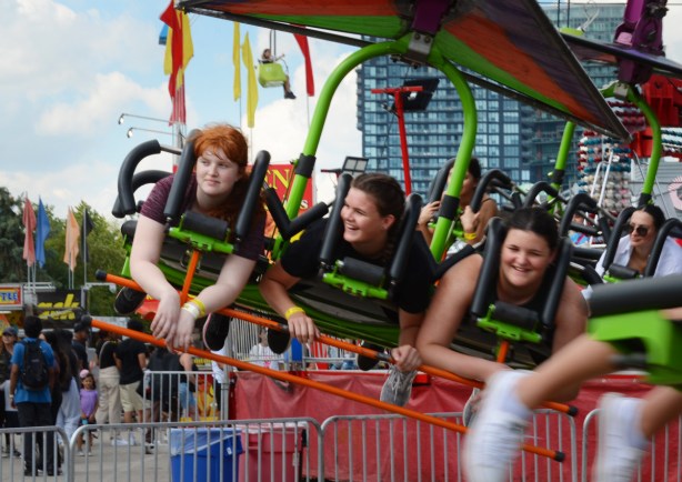 three young people in prone position in a ride at the cne