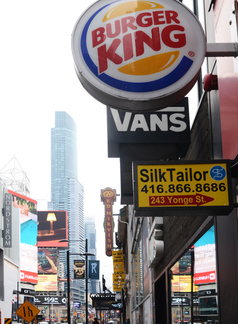 store signs on Yonge Street, Burger King, a tailor shop, vans, and Ed Mirvish theatre