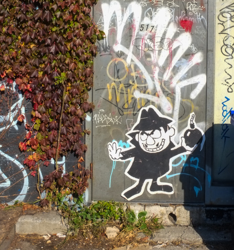graffiti, black and white wheatpaste of Boris Badenov, cartoon character from Rocky and Bullwinkle show, about the throw a round black bomb, evil look on his face