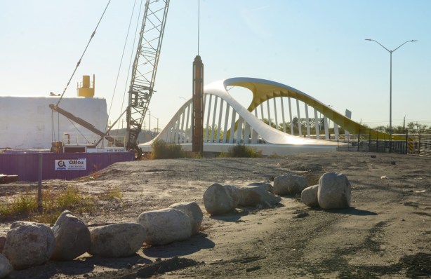 new Cherry Street bridge with its yellow curved lines, large rocks in the dirt in the foreground, construction still in progress