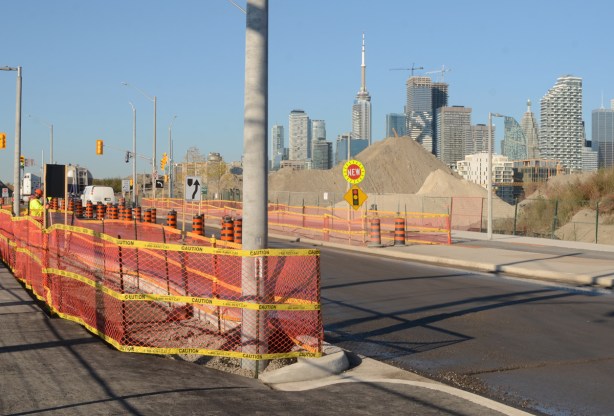 construction along the west end of Commissioners street in the port lands, with the toronto skyline in the background