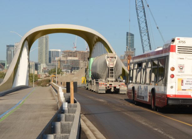 a cement truck and a ttc bus on Cherry street on the new bridge 
