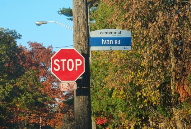 stop sign at all way stop with a toronto road sign for Ivan Road, with top part that says Centennial Community