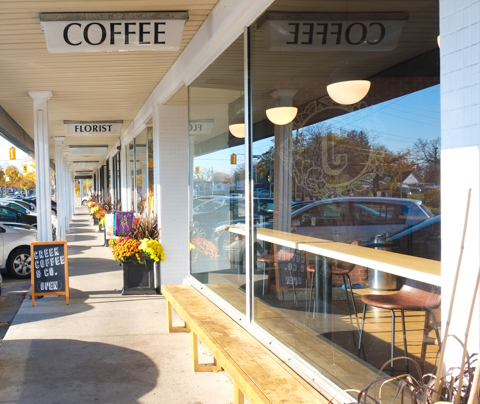 exterior, strip mall, outside Creek Coffee Company on a sunny day