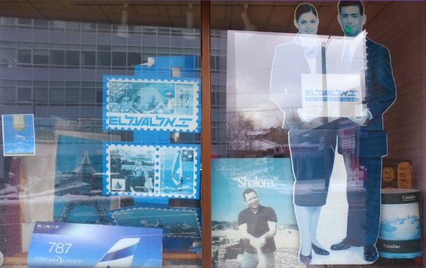 faded, blue tinted, travel posters in hebrew in a store window