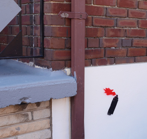 spray painted in black, stencil of spray paint can with red flames coming out of it
