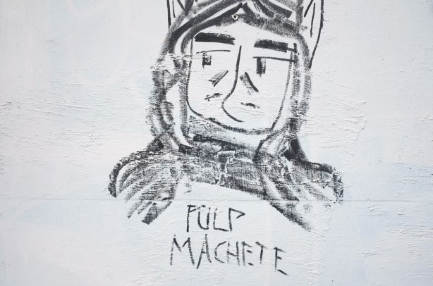 black drawing of a man's portrait, wearing hat, text underneath says pulp machete