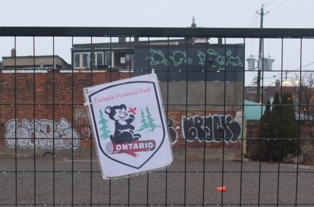 the word Ontario written on a log, with a cute little black and white animal (skunk? bear?) sitting on it