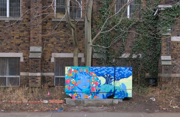 painted metal bell box on a sidewalk in front of a church
