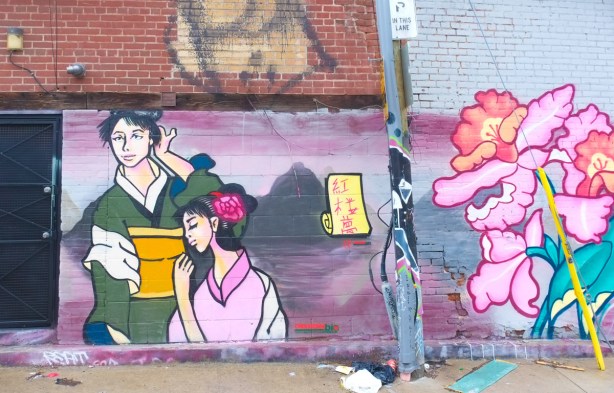 an asian couple, woman in pink with flower in her hair, man in green, 