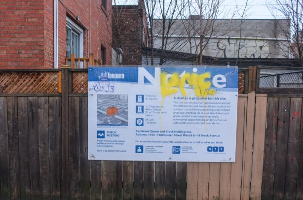 blue and white city of toronto development notice sign on a wood fence