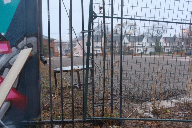 small table in a vacant lot, behind a fence, houses on Brock Ave in the background