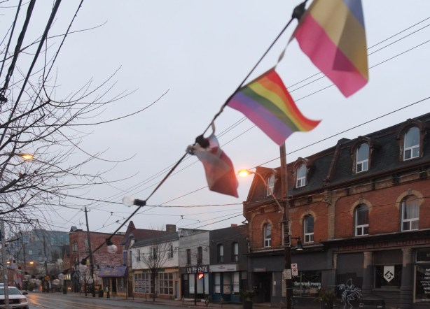 coloured flags flying over Queen Street West 