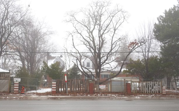 large house waiting to be demolished, behind fence