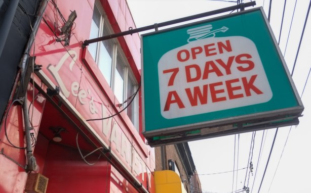 sign for Lees convenience store, milk jug shape in white with red letters that say open 7 days a week 
