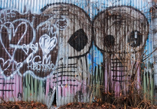 corrugated metal wall or fence with little alien spacemen graffiti 