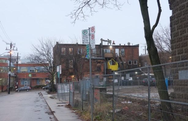 vacant lot behind brick building on the northwest corner of Noble and Queen West 