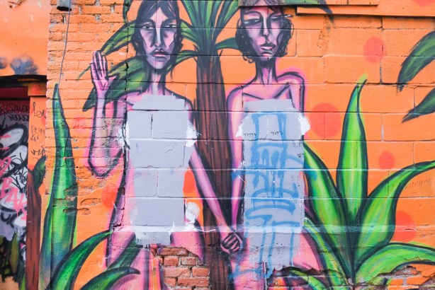 old mural by Philip Saunders, a couple holding hands, origianlly with no clothes on but the bodies have been painted over and their modesty preserved