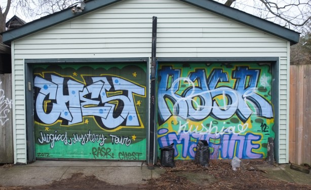 double garage doors, one side painted by chest and says magic mystery tour and the side painted by rasr and says imagine, painted in 2012 