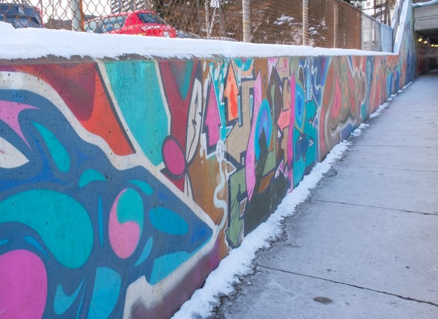 wall beside sidewalk at railway underpass, abstract