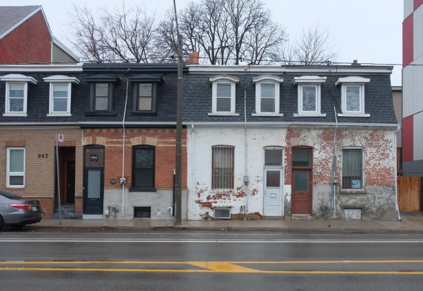 old brick two storey rowhouses with black mansour roof with upper windows in roof