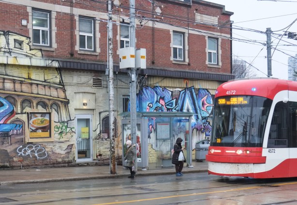 people getting on and off TTC streetcar at Broadview and Gerrard