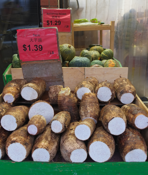 piles of taro root and butternut squash for sale
