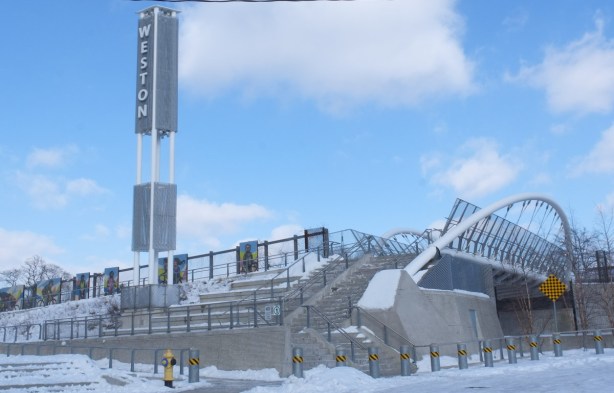 western approach to pedestrian bridge over train tracks, with display of cyclists over the decades painted by elicser elliott