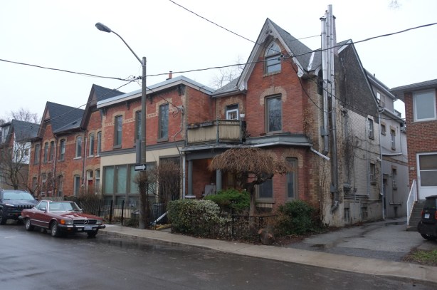 a row of brick houses, most with yellow brick contrasting detail near the roofline