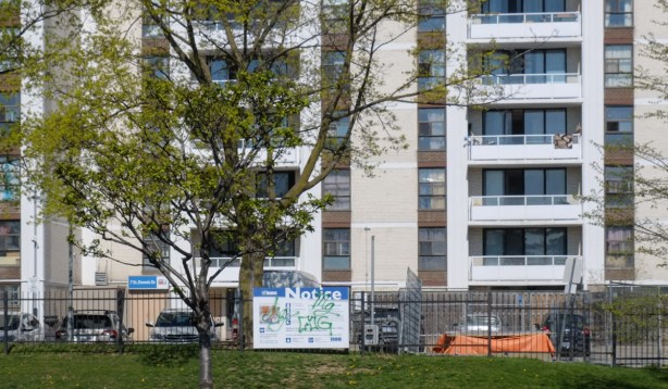 brick highrise apartment building on Don Mills Road with development notice sign in front of it 