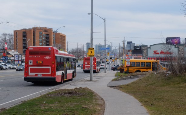 2 TTC buses on Lawrence, a school bus parked beside, 
