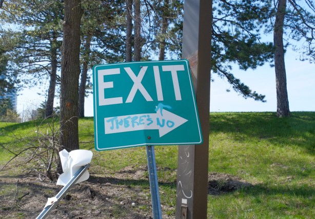 green exit sign with an arrow pointing to the right on which someone has written there's no, sign now says there's no exit