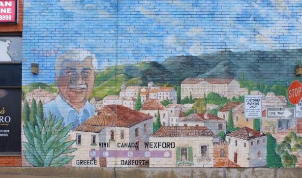 Man's portrait, Tony, on a mural along with picture of a village in Greece, words, Greece, Canada, Danforth, Wexford,