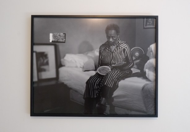 black and white photo by Anique Jordan, woman sitting on a bed with half a watermelon, black and white
