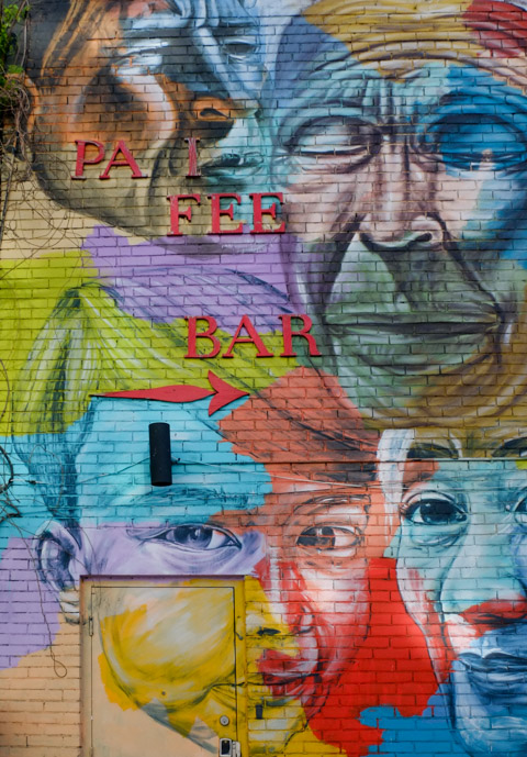 Troy Lovegates mural, faces by the side door, including a younger person 