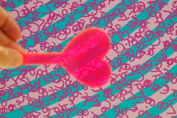 pink heart shaped plastic beside a wall of blue and pink stripes