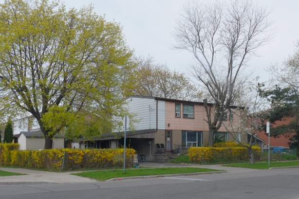 house with pale pink siding on upper floor, spring