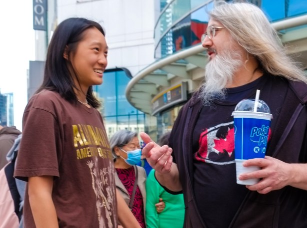 two men talking together, one has a long white beard and white hair