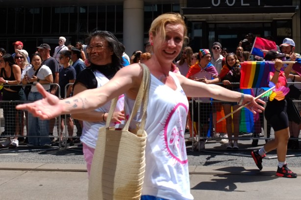 woman walking in pride parade, crowds behind her