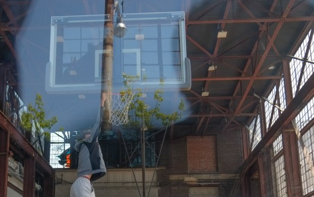 looking through a window to young men playing basketball inside
