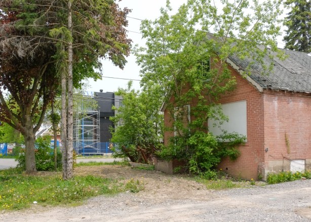 small brick house with boarded up windows
