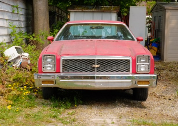 old red car in driveway of a house