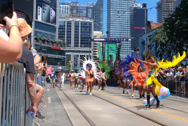 group with feather costumes walking in pride parade
