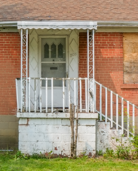 front porch and front door of old brick house now empty
