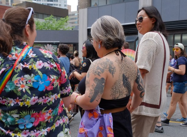 group pf women at dyke march in downtown toronto, one woman heavily tattooed on back and shoulders
