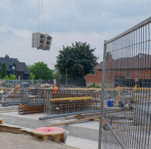 looking into a construction site, cranes lifting heavy object