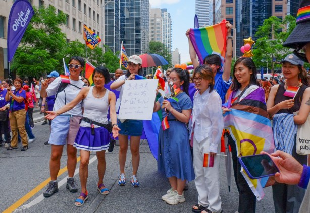 women in dyke march along Bloor street in Toronto, a group poses with candidate in mayor election, Olivia Chow